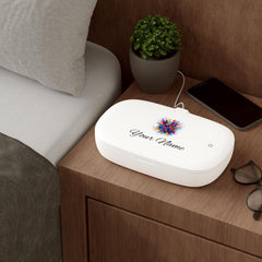 A white UV sanitizer box with a watercolor splash graphic and the text Your Name is angled open with a power cord attached.